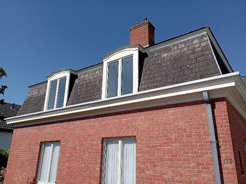 Bakstenen huis met dakkapellen en grijze dakpannen