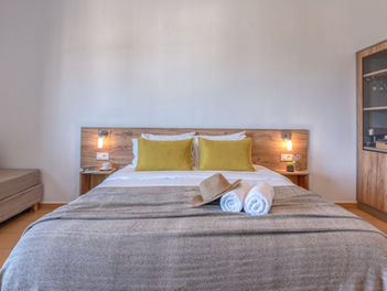 Queen size bed in a hotel room in Kissamos