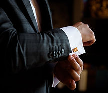 Man adjusting gold cufflinks
