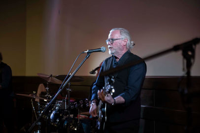 Man singing and playing guitar at a GrowNow event