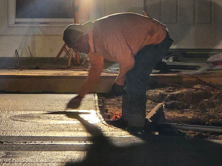 Crew installing pavers or concrete flooring for an outdoor construction project
