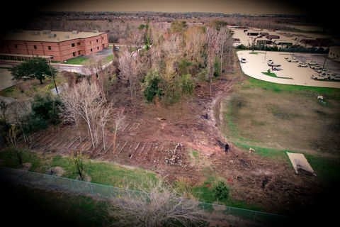 Aerial view of land clearing with buildings and trees near by land clearing near me