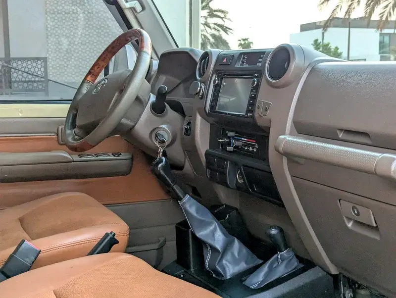 Miniature : Intérieur de voiture avec volant en bois, tableau de bord et sièges marron.