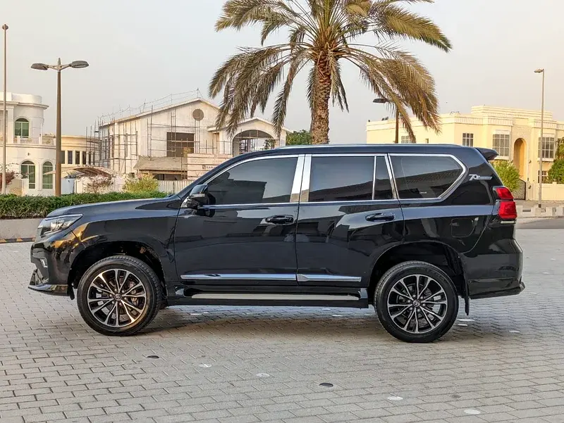 Miniature : SUV noir garé, avec un palmier en arrière-plan urbain.