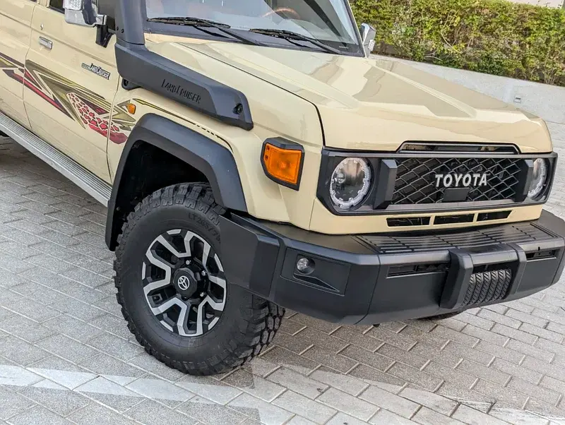 Miniature : SUV beige TOYOTA Land Cruiser avec snorkel et pneus tout-terrain robustes.