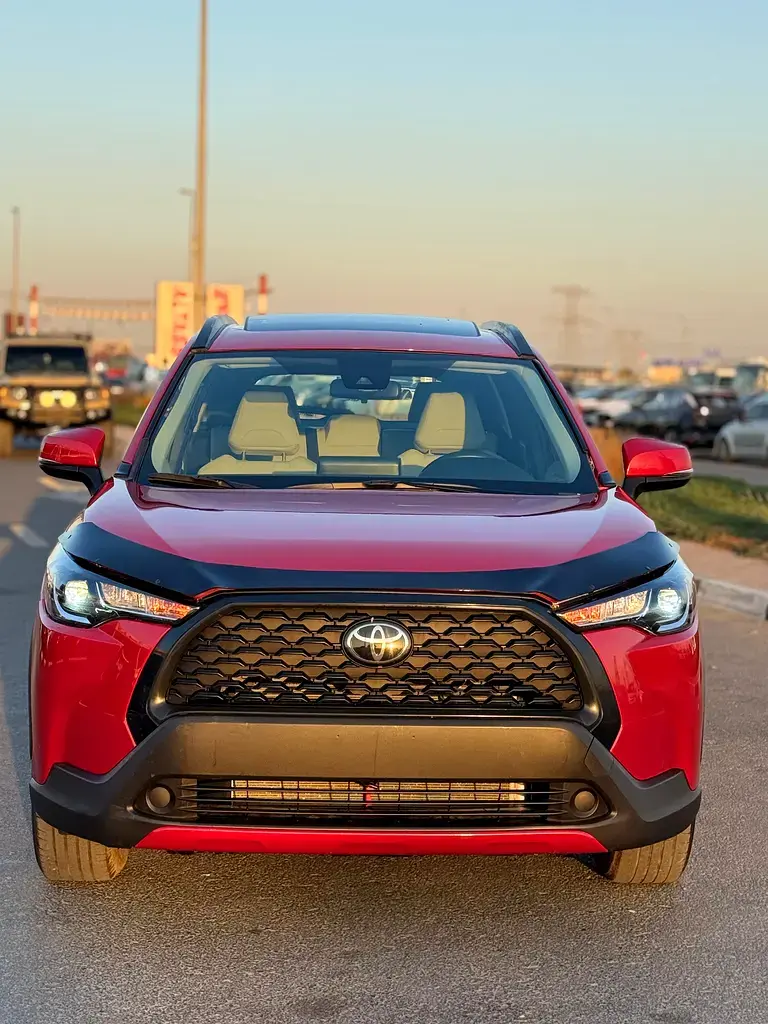 Crossover Toyota rouge, vue de face, garé sur route.