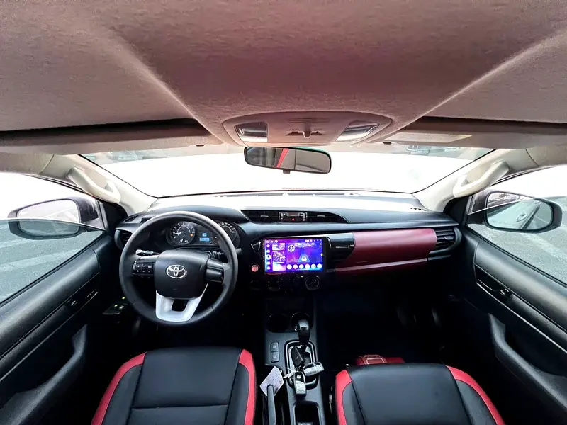 Miniature : Intérieur de voiture Toyota moderne avec écran, sièges noirs et rouges.