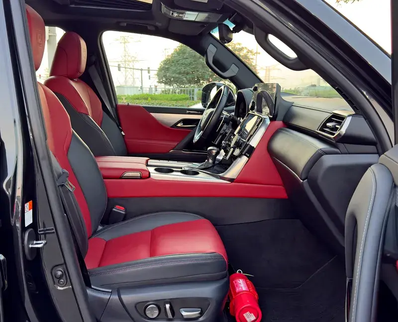 Miniature : Intérieur luxueux de voiture avec sièges cuir rouge et noir, extincteur.