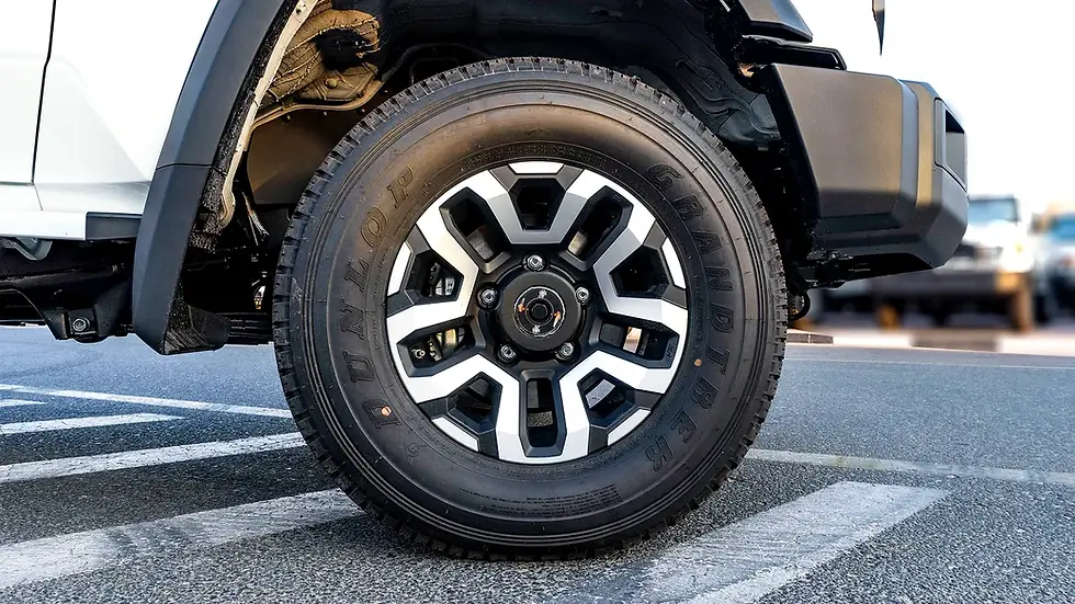 Miniature : Roue de voiture avec pneu DUNLOP GRANDTREK et jante bicolore sur chaussée.