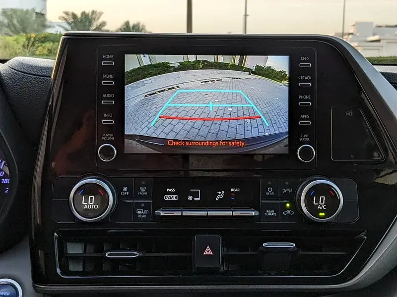 Miniature : Écran de voiture affichant la caméra de recul, "Check surroundings for safety".