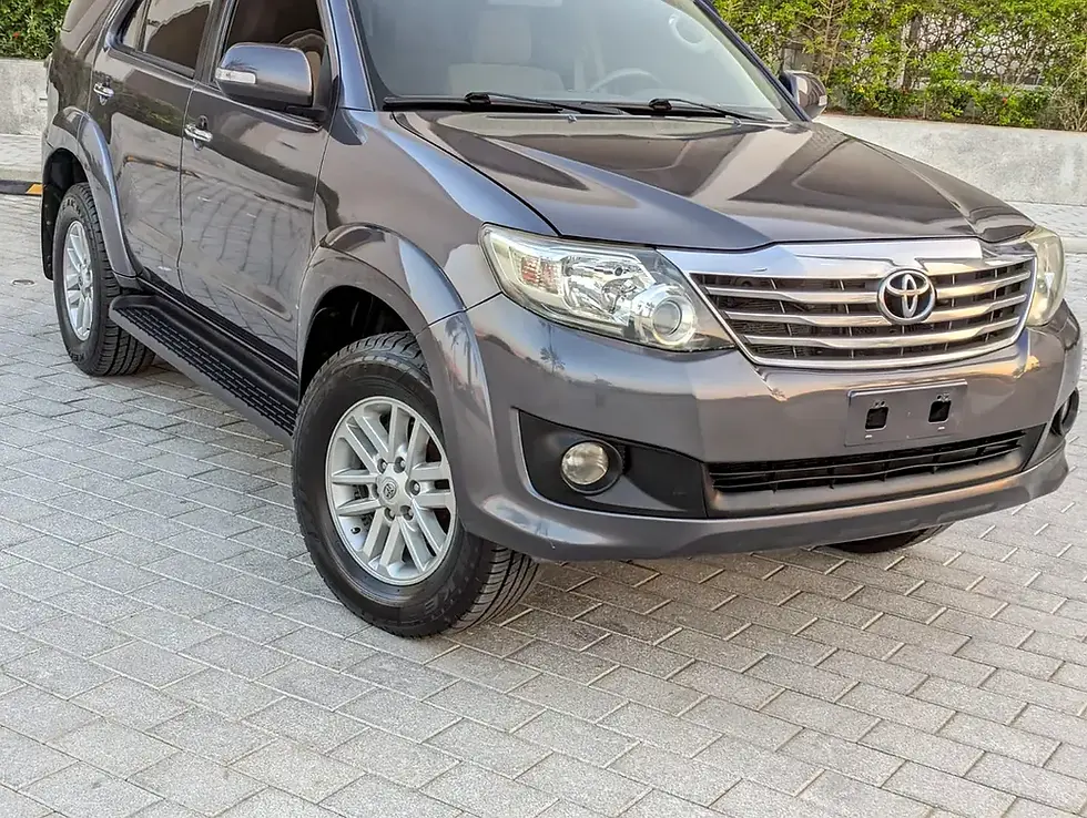 Miniature : Gros SUV gris foncé Toyota garé sur un sol pavé.