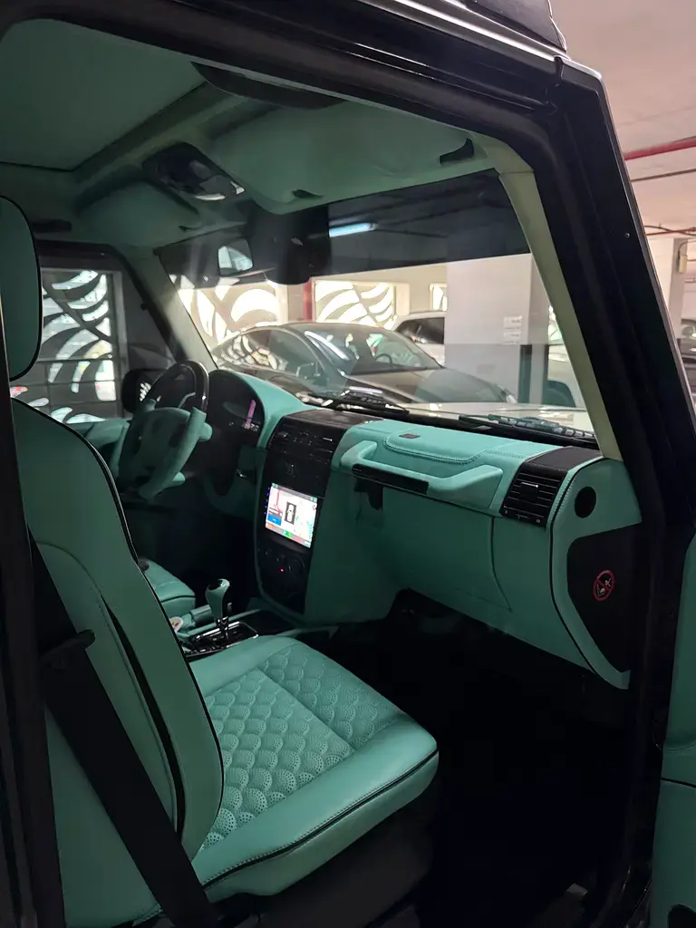 Miniature : Intérieur de voiture de luxe vert menthe avec sièges matelassés.