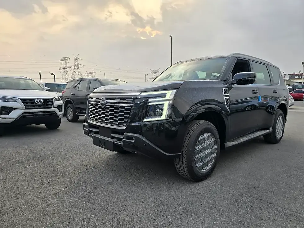 SUV noir garé en extérieur, d'autres véhicules en arrière-plan.