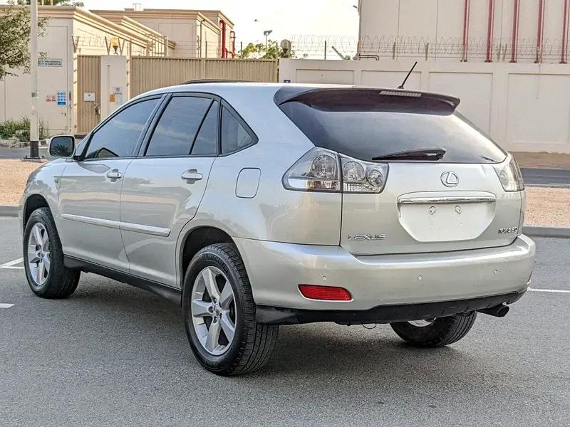 Miniature : Vue arrière d'un SUV Lexus RX argenté, stationné à l'extérieur.