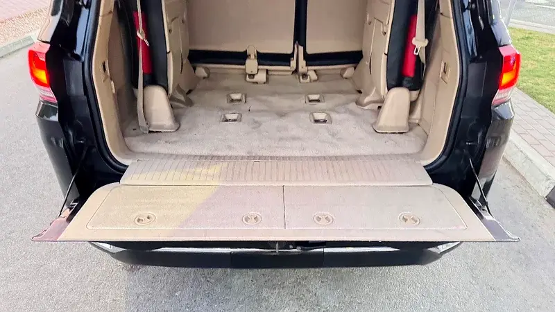 Miniature : Coffre arrière ouvert d'un SUV noir, intérieur beige et sièges rabattus.