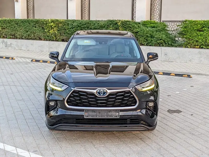 Miniature : SUV Toyota Highlander noir garé devant un bâtiment moderne.