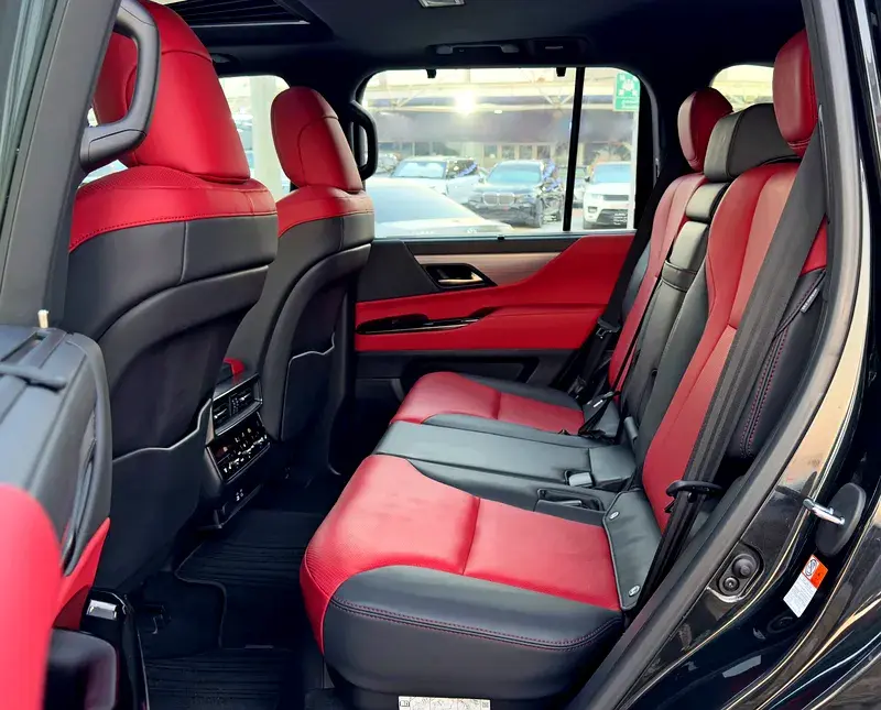 Miniature : Intérieur luxueux de voiture, sièges arrière en cuir rouge et noir.