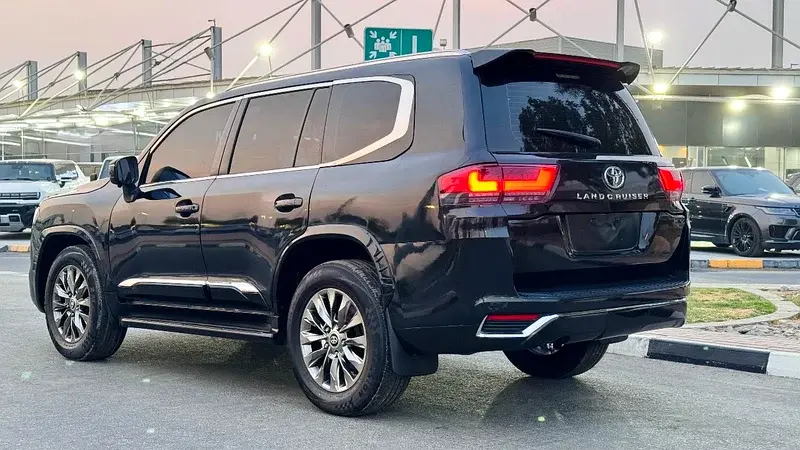 Miniature : SUV noir Land Cruiser garé, vue arrière, texte 'LAND CRUISER'.