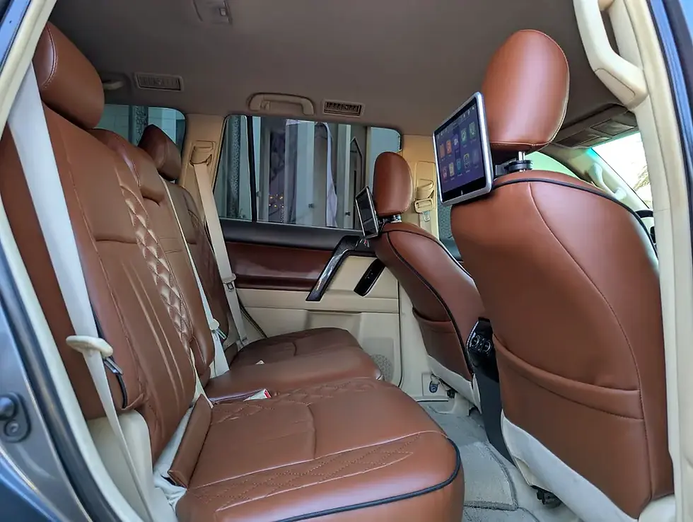 Miniature : Intérieur de voiture avec sièges arrière en cuir marron et tablette numérique.