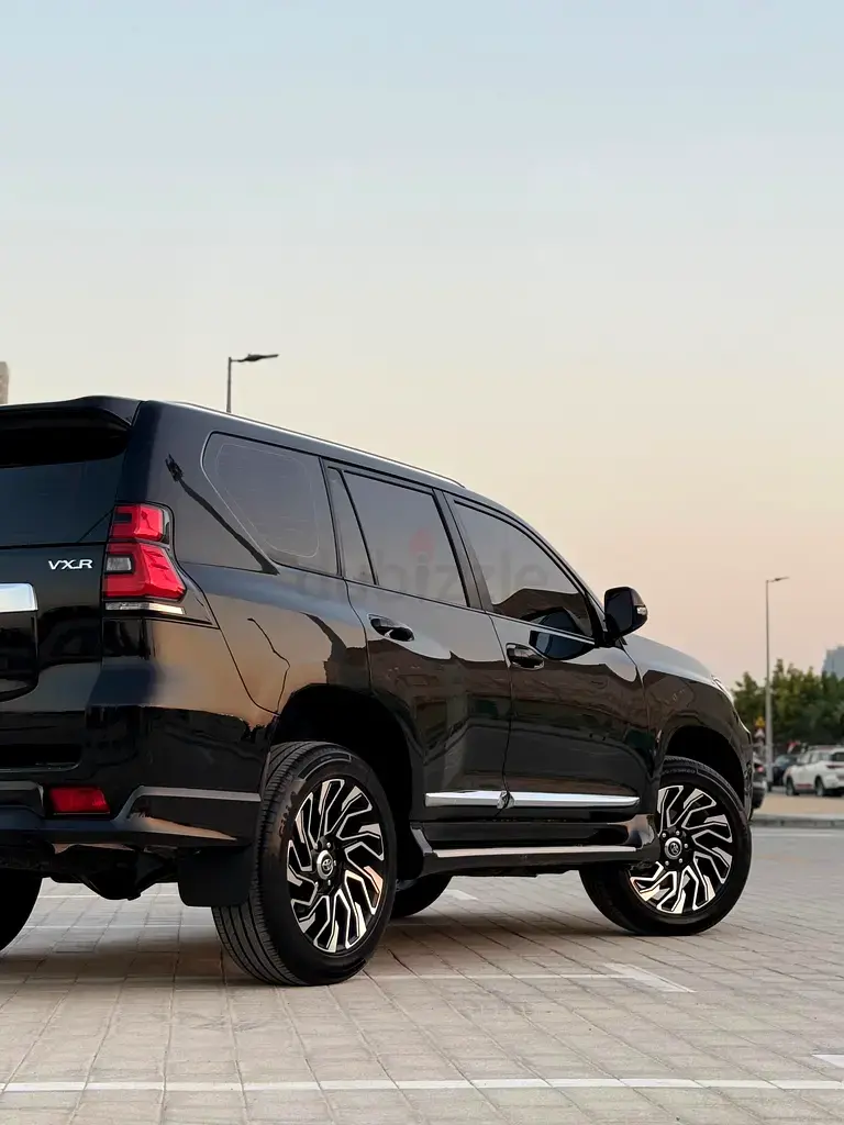 Miniature : SUV noir Toyota Land Cruiser Prado VX.R stationné, roues personnalisées.