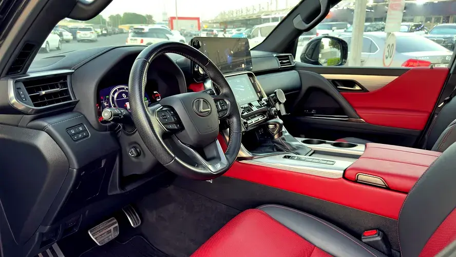 Miniature : Intérieur luxueux d'une Lexus, sièges en cuir rouge et noir, volant.