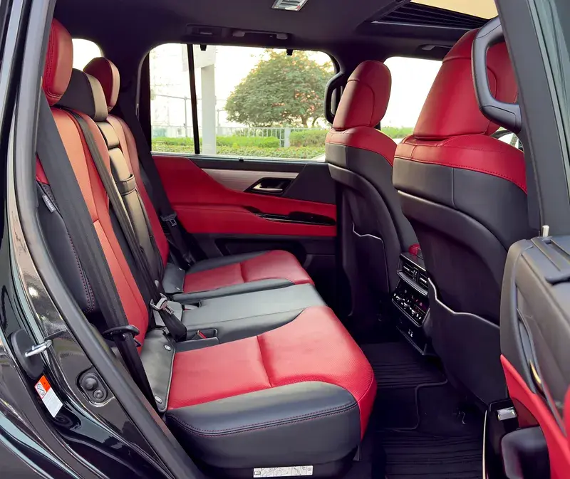 Miniature : Intérieur de voiture luxueux avec sièges arrière en cuir noir et rouge.