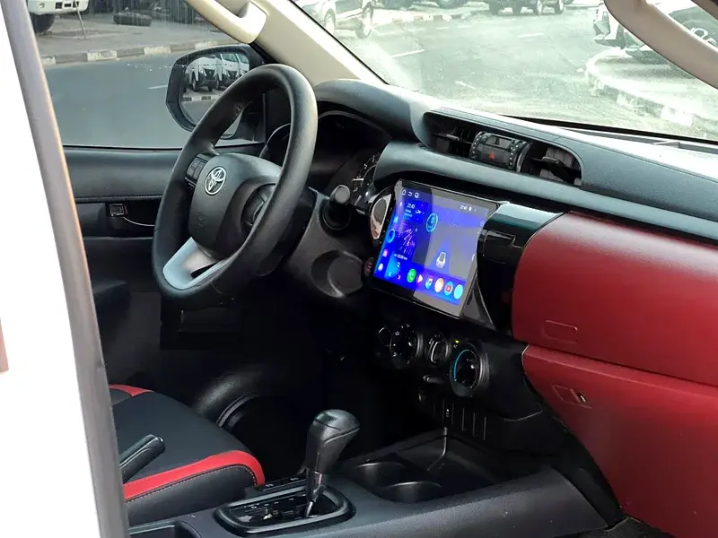 Miniature : Habitacle moderne Toyota, écran multimédia tactile, volant et accents rouges.