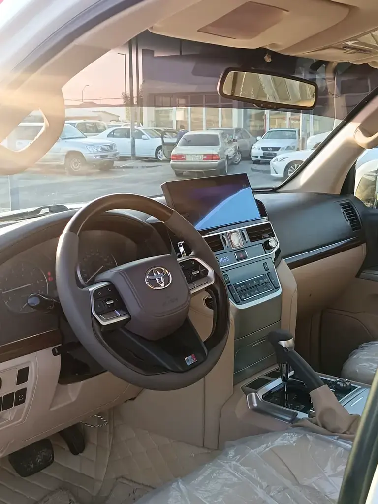 Miniature : Intérieur de voiture beige, volant, écran tactile et tableau de bord moderne.