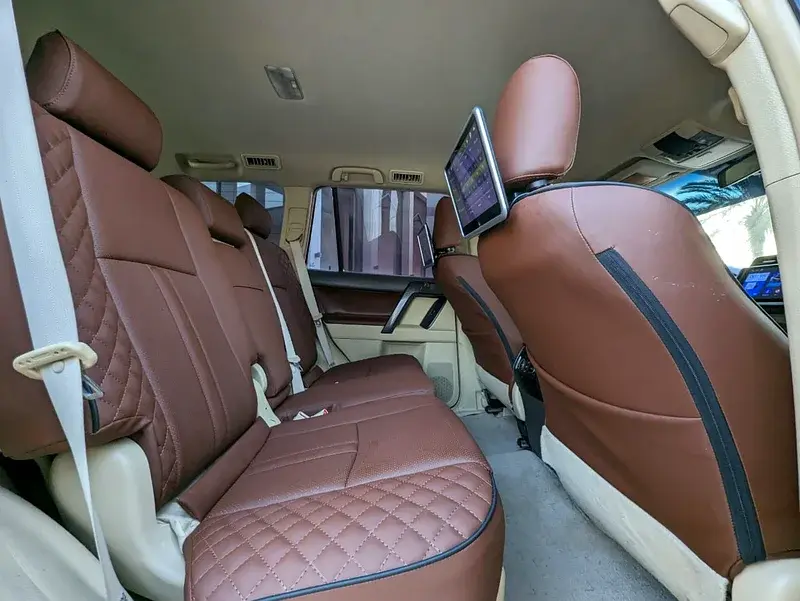 Miniature : Intérieur de voiture avec sièges en cuir marron et écran sur l'appui-tête.