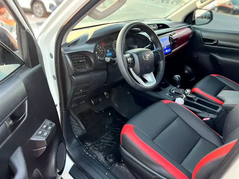 Miniature : Intérieur de voiture moderne avec sièges cuir noir et rouge, logo Toyota.