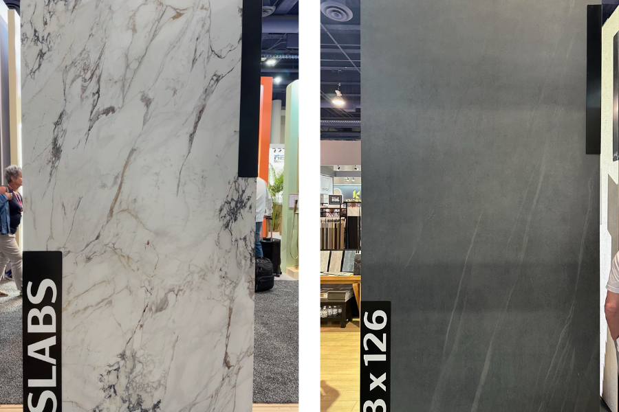 Large format kitchen slabs on display at a design show, featuring marble-look and matte charcoal finishes—trending materials for modern countertops and backsplashes.