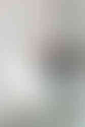 Close-up of a walk-in shower with custom glass doors and herringbone-patterned tile