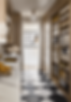 Elegant walk-through pantry and prep space with checkered tile floors, brass accents, and curated open shelving—a nod to the growing trend of hidden utility with elevated style.