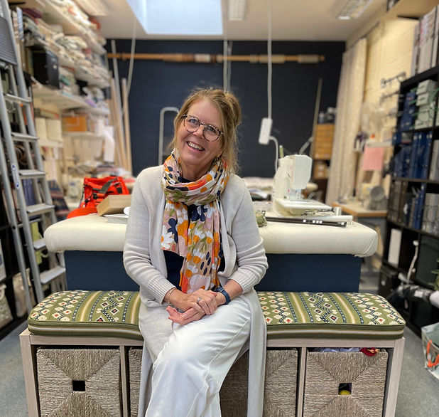 Susan Taylor seated on a bench cushion in the workshop