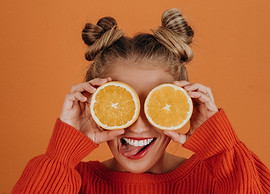 jeune femme qui fait une grimace avec un agrume sur les yeux