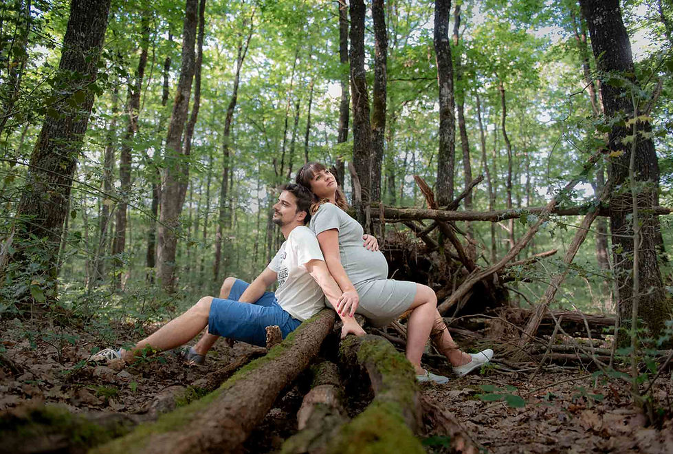 Couple attend un bébé, tendrement enlacé lors d'une séance photo en pleine nature