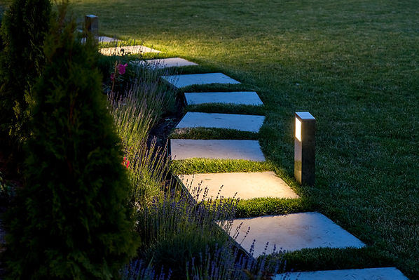 marble path of square tiles illuminated by a lantern glowing with a warm light in a backya
