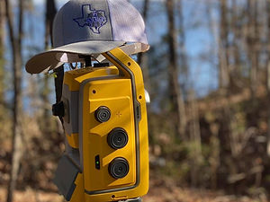 Artistic photo of Bline hat on total station in the woods
