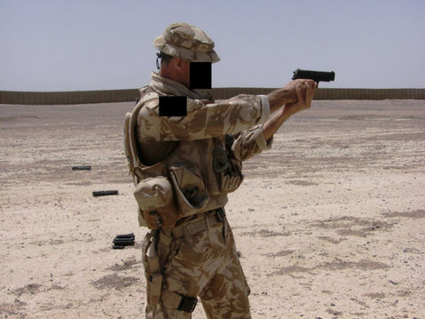 Charlie Aston firing pistol in desert