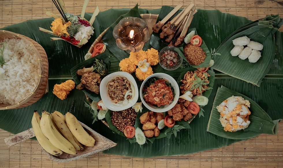Megibung style lunch set on giant banana leaf with traditional balinese food