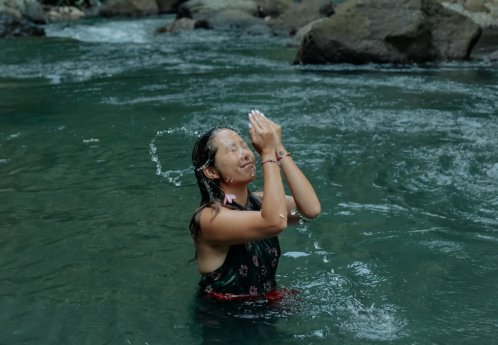 girl during purification ritual in the sacred river in Bali
