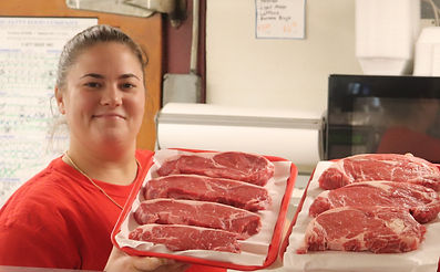 An employee displaying some high quality freshly cut New York Sirloin Steak