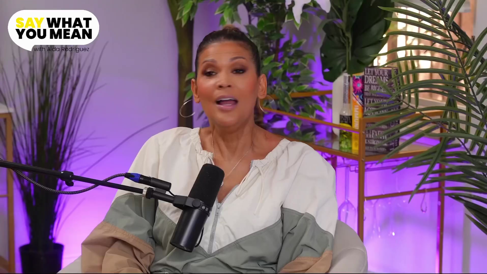 Aida Rodriguez speaking into a microphone on the Upodcaster set