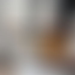 Two engineers lean towards the table and point to a laptop. Next to it are a hard hat and protective glasses.