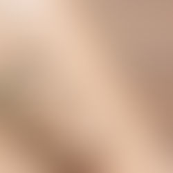 A close-up shows a leather bag strap with a metal buckle and stitching details resting diagonally on a wooden surface.