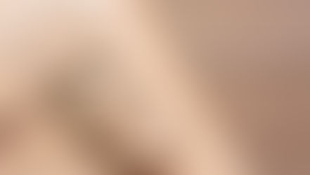 A close-up shows a leather bag strap with a metal buckle and stitching details resting diagonally on a wooden surface.