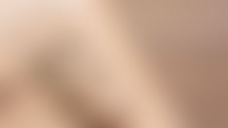 A close-up shows a leather bag strap with a metal buckle and stitching details resting diagonally on a wooden surface.