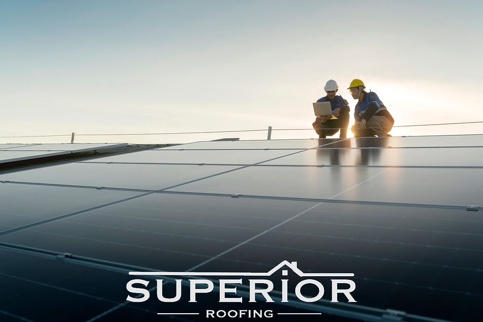Two roof workers in hard hats inspect solar panels at sunset, one using a laptop; SUPERIOR ROOFING text below.