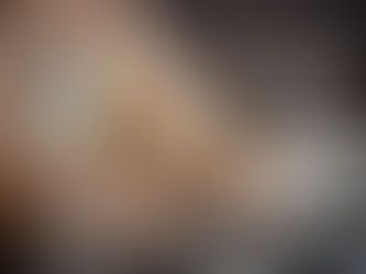 Hands typing on a laptop with transparent screens showing SEO text, graphs, and icons. Background is soft-focus with warm tones.