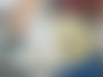 Worker holding a large roll of insulation material. Wearing gloves and a harness, set in an industrial environment. Blue and gray tones.